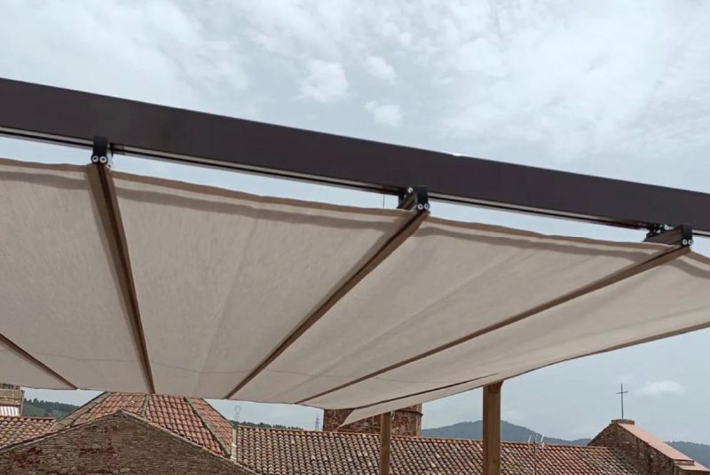 Toldo corredero integrado en la pérgola de madera, con lona acrílica y accionamiento manual